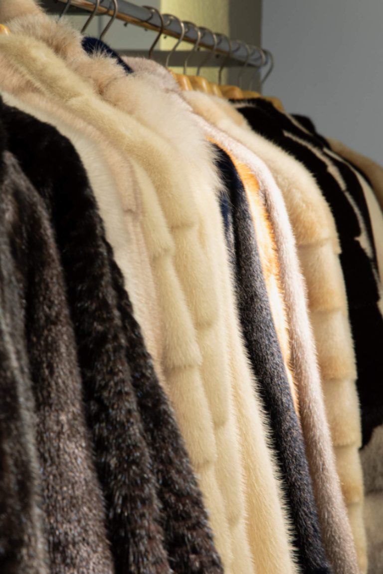 multiple different fur coats on a rack