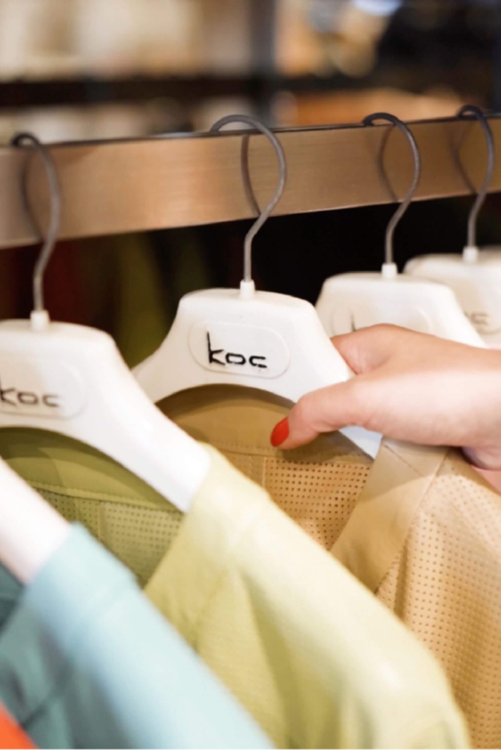 a hand holding a white swinger with a few shirts on it