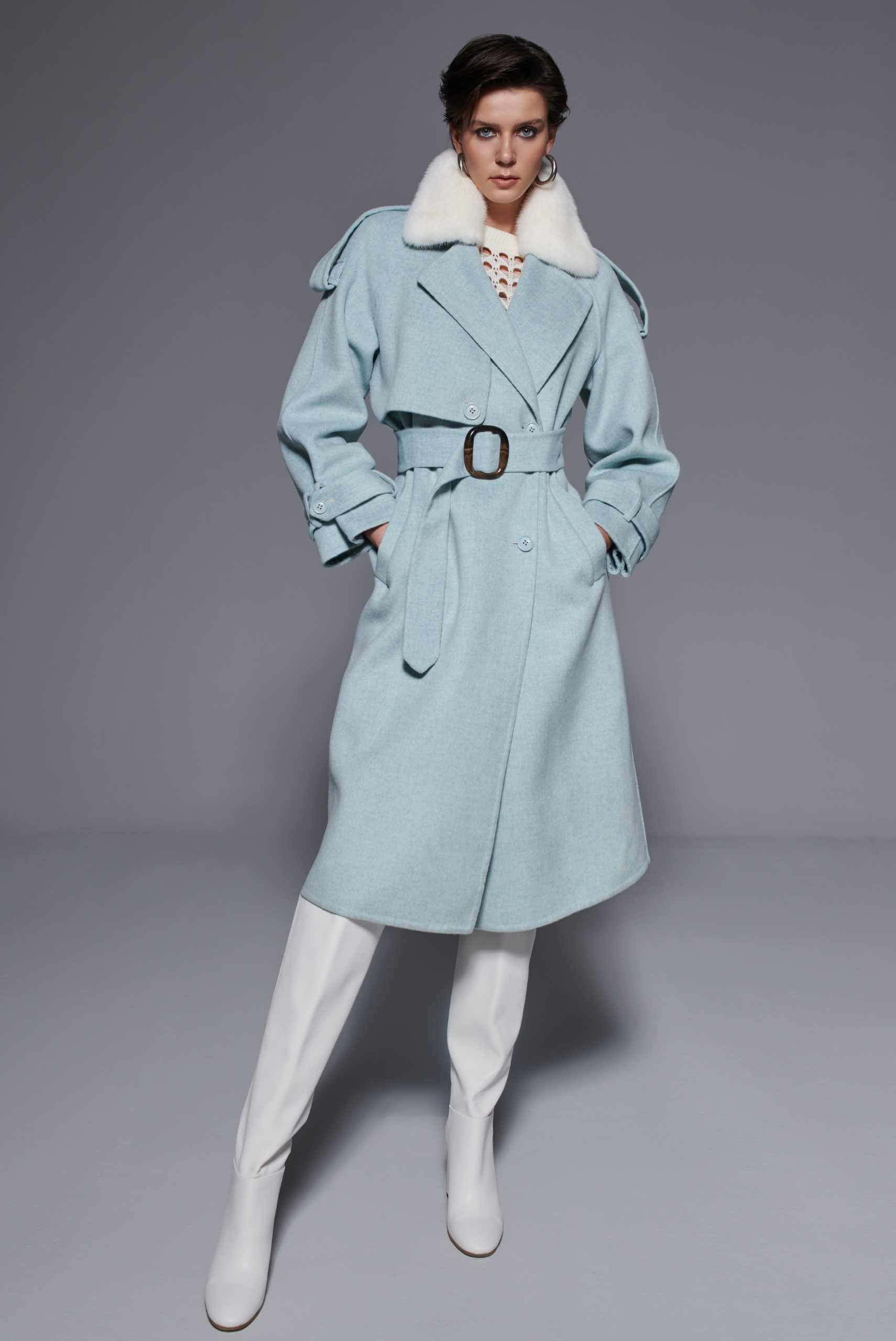 Woman wearing a light blue wool coat with a white fur collar — elegant design by Koç Leather & Fur, Istanbul.